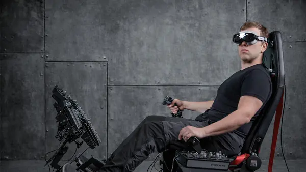 Een simmer in een cockpit met joystick en pedalen draagt de lichte Pimax Dream Air